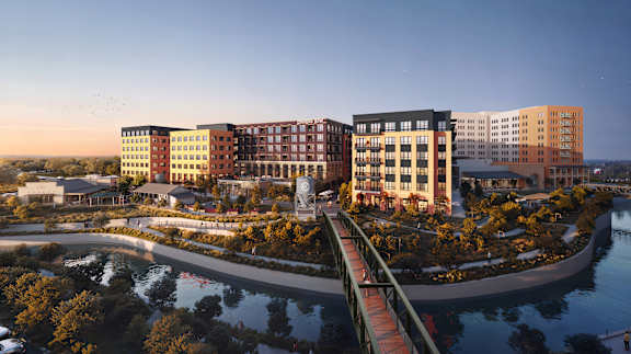 A modern building complex with a bridge over a body of water.