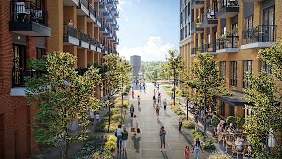 A street view of a residential area with people walking and trees lining the street.