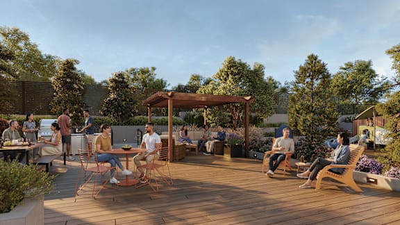 A group of people are sitting and standing on a wooden deck.