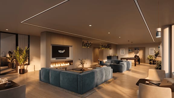A modern living room with a large blue sofa and a flat screen TV mounted on the wall.
