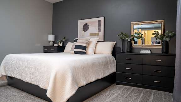 a bedroom with black furniture and a white bed
