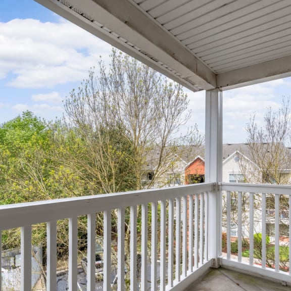 the view from the deck of a house with a yard and trees