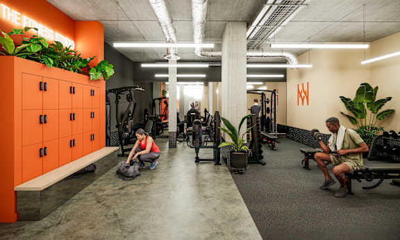 A gym with orange lockers and people working out.