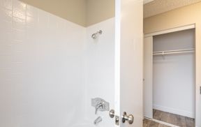 A white door with a silver handle and a silver shower head.