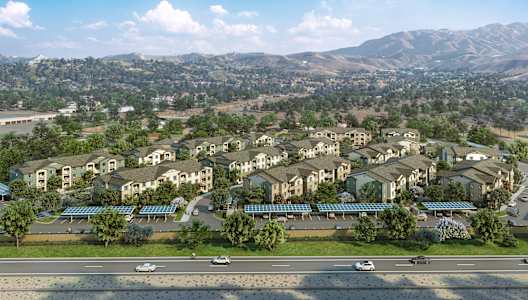 A large housing complex with a parking lot in front.