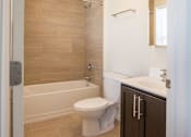 Thumbnail 11 of 11 - bathroom with beige tile and wooden cabinet
