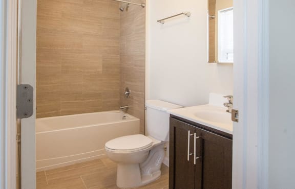bathroom with beige tile and wooden cabinet