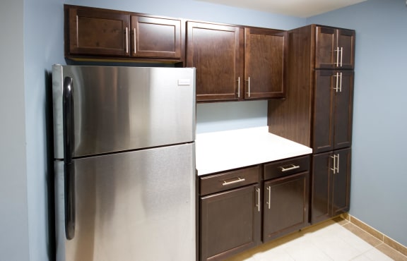 Kitchen with dark wooden cabinets and stainless steel refrigerator