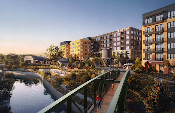 A pedestrian is walking on a bridge over a river in a city.