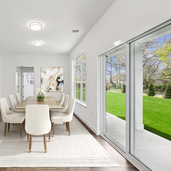 a kitchen and dining room with a table and chairs at The Arboretum Apartments, Farmingville, NY