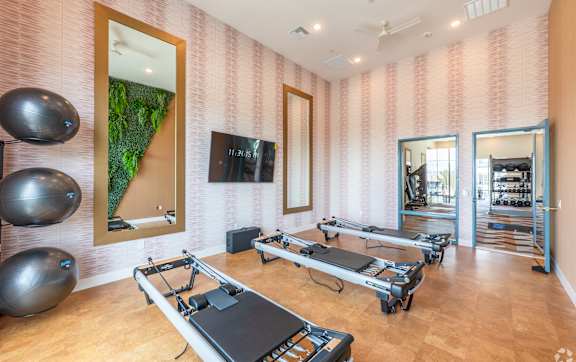 a group of women in a yoga class doing pushups on the floor at Fora Apartments in Las Vegas, NV