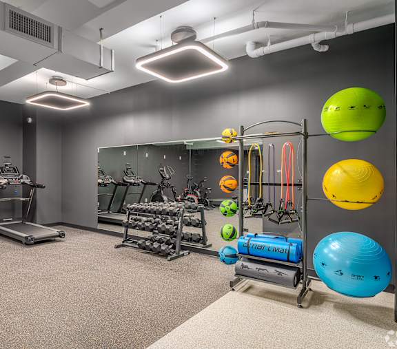 A gym with treadmills, exercise balls, and other equipment.