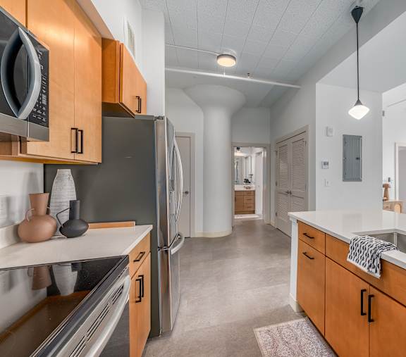 A kitchen with wooden cabinets and a black refrigerator.