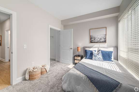 A bedroom with a large bed and a picture on the wall.at Park Lamont Apartments & Townhomes, Ohio