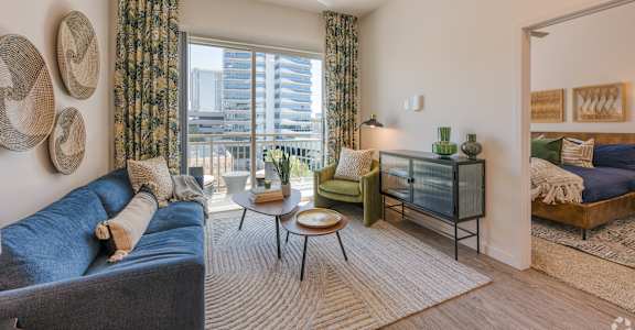 a living room with a blue couch and a large window at Aura Vegas Apartments, Nevada, 89103