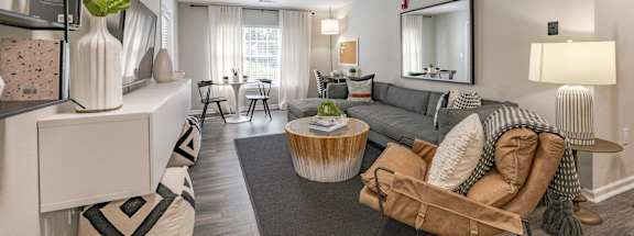 A living room with a grey couch and a wooden coffee table.