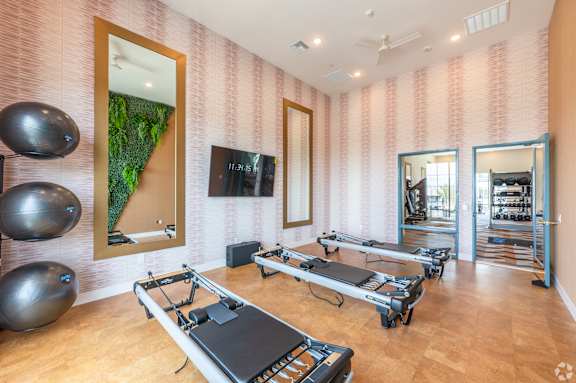 A room with pilates reformers and exercise balls.