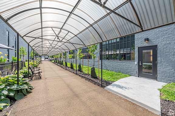 A pathway with a rocky bed on the side and a building in the background.at Life At Agora Apartments, Ohio, 44103