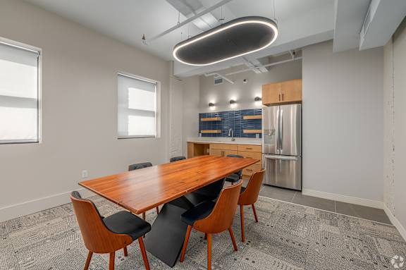 A modern living room with a grey sofa and a bar area. at Life At Agora Apartments, Cleveland, OH