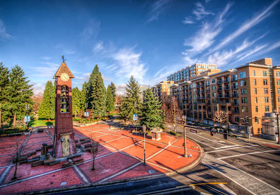 A clock tower stands in the middle of a courtyard.