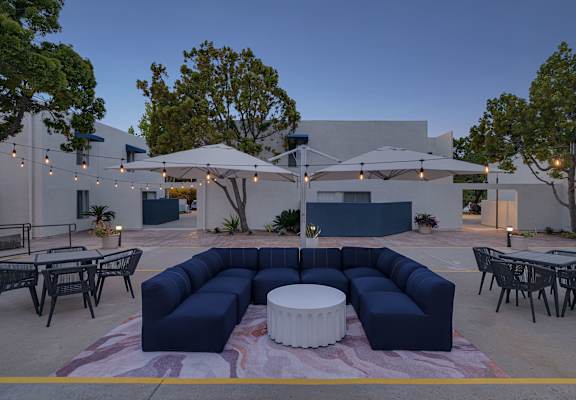 A patio with a white table and blue couches.