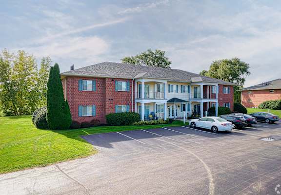 a large brick house with cars parked in front of it at Centerpointe Apartments, Canandaigua