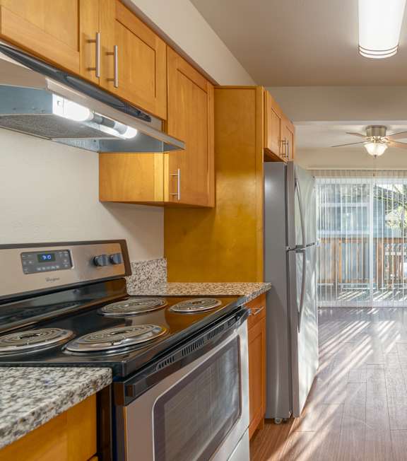 A kitchen with wooden cabinets and granite countertops.