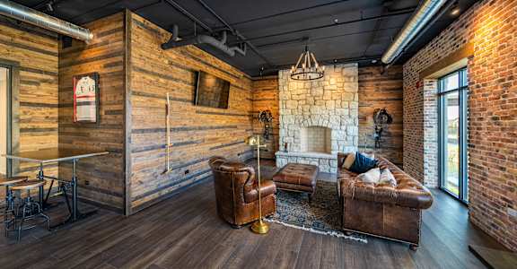 a living room with leather furniture and a stone fireplace