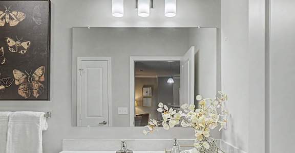 A white bathroom with a sink and a mirror.