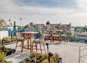 Thumbnail 1 of 6 - A patio with a table and chairs overlooking a street.