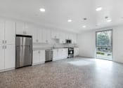 Thumbnail 18 of 28 - A kitchen with white cabinets and a tiled floor.