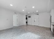 Thumbnail 22 of 28 - A large empty room with a tiled floor and white walls.