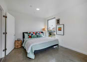 Thumbnail 12 of 28 - A bedroom with a bed, pillows, and pictures on the wall.