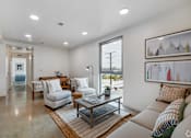 Thumbnail 10 of 28 - A modern living room with a large window and a view of the outdoors.