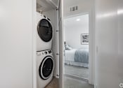 Thumbnail 8 of 28 - A white laundry room with a washer and dryer in it.