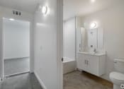 Thumbnail 5 of 28 - A white bathroom with a toilet, sink, and mirror.