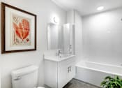 Thumbnail 3 of 28 - A white bathroom with a white toilet, sink, and bathtub.