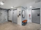 Thumbnail 5 of 6 - A room with a bench, a mirror, and a fire extinguisher.