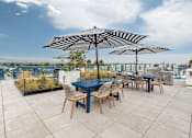 Thumbnail 20 of 28 - A patio with a table and chairs under umbrellas.