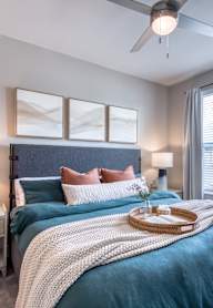 A bedroom with a large bed and a ceiling fan.