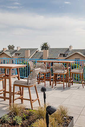 A patio with a table and chairs overlooking a street.