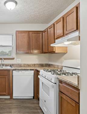 A kitchen with white appliances and wooden cabinets.