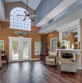 A living room with a fireplace and a dining table.