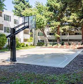 an outdoor basketball court in front of an apartment building