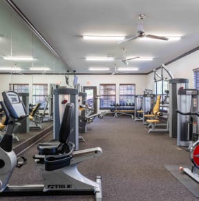 Sugar Mill Apartments in Addis, LA photo of a gym with cardio equipment and weights in a building with windows