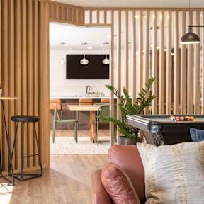 A modern living room with a bar stool and a couch.