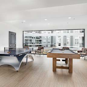 A pool table in a room with a view of a city.