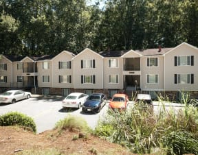 an apartment building with cars parked in front of it at Hidden Woods, Decatur, GA, 30035