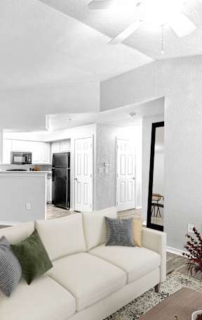 A living room with a white couch and a dining table.