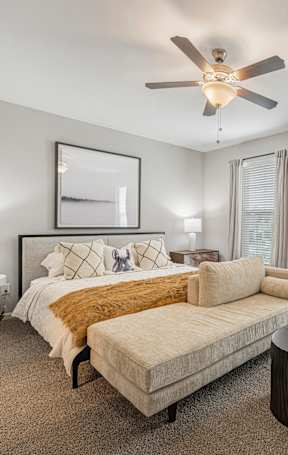 a bedroom with a bed and a ceiling fan
